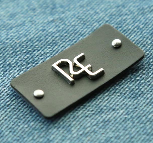 Delicate metal label branded leather patch in garment